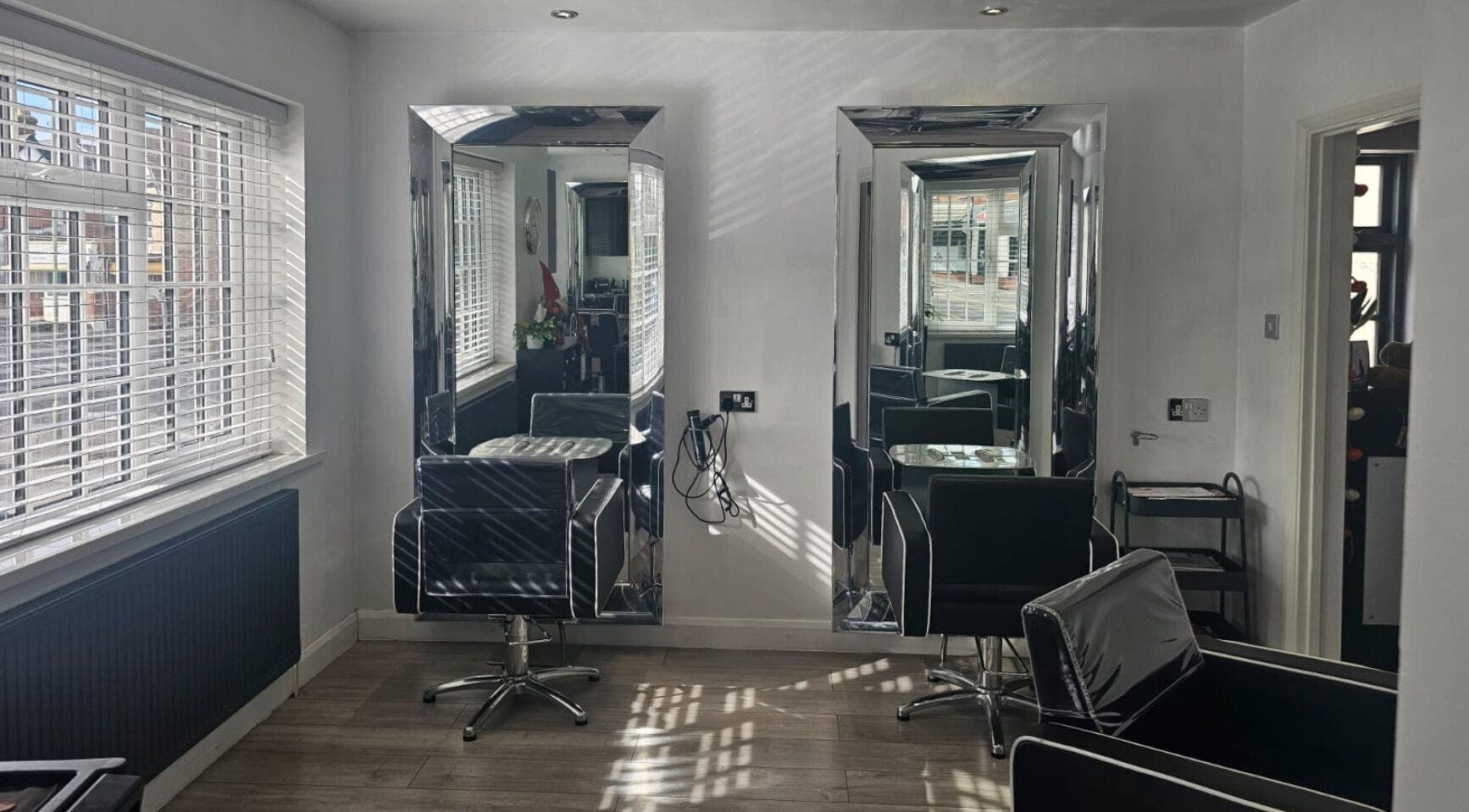 Sleek chairs and mirrors at Hideaway Hair Salon, Park Gate, England, GB, showcasing elegant salon design.