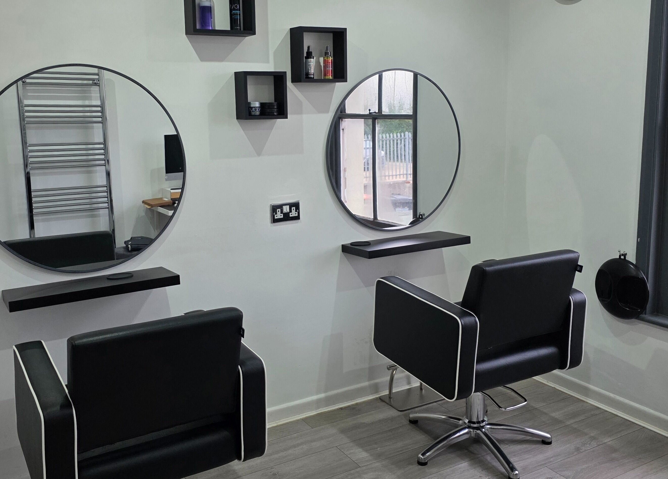Modern styling stations at Hideaway Hair Salon, Park Gate, England, GB showcasing sleek design and comfort.