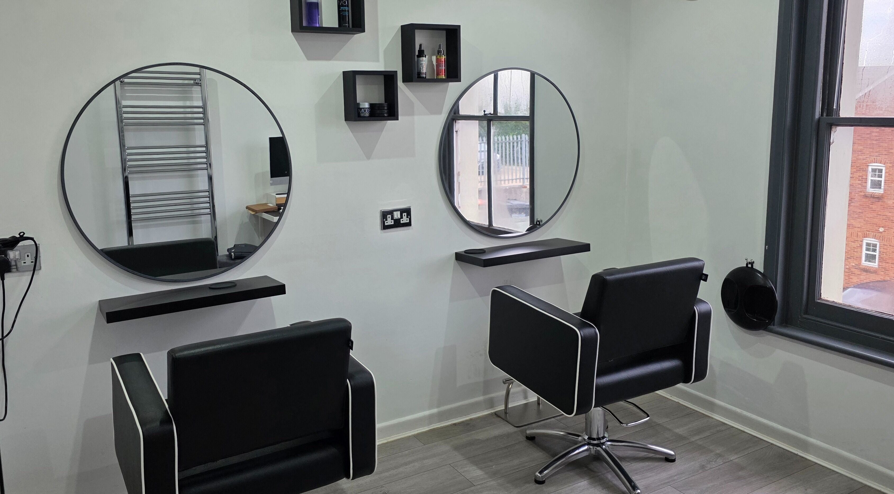 Modern styling stations at Hideaway Hair Salon, Park Gate, England, GB showcasing sleek design and comfort.