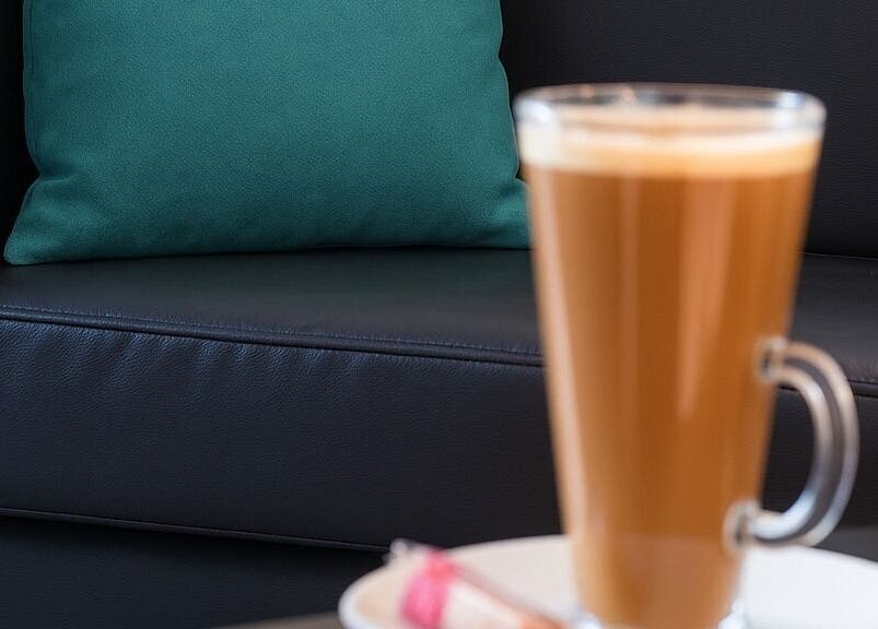 Relaxing lounge with teal pillow and coffee at Hideaway Hair Salon, Park Gate, England, GB.