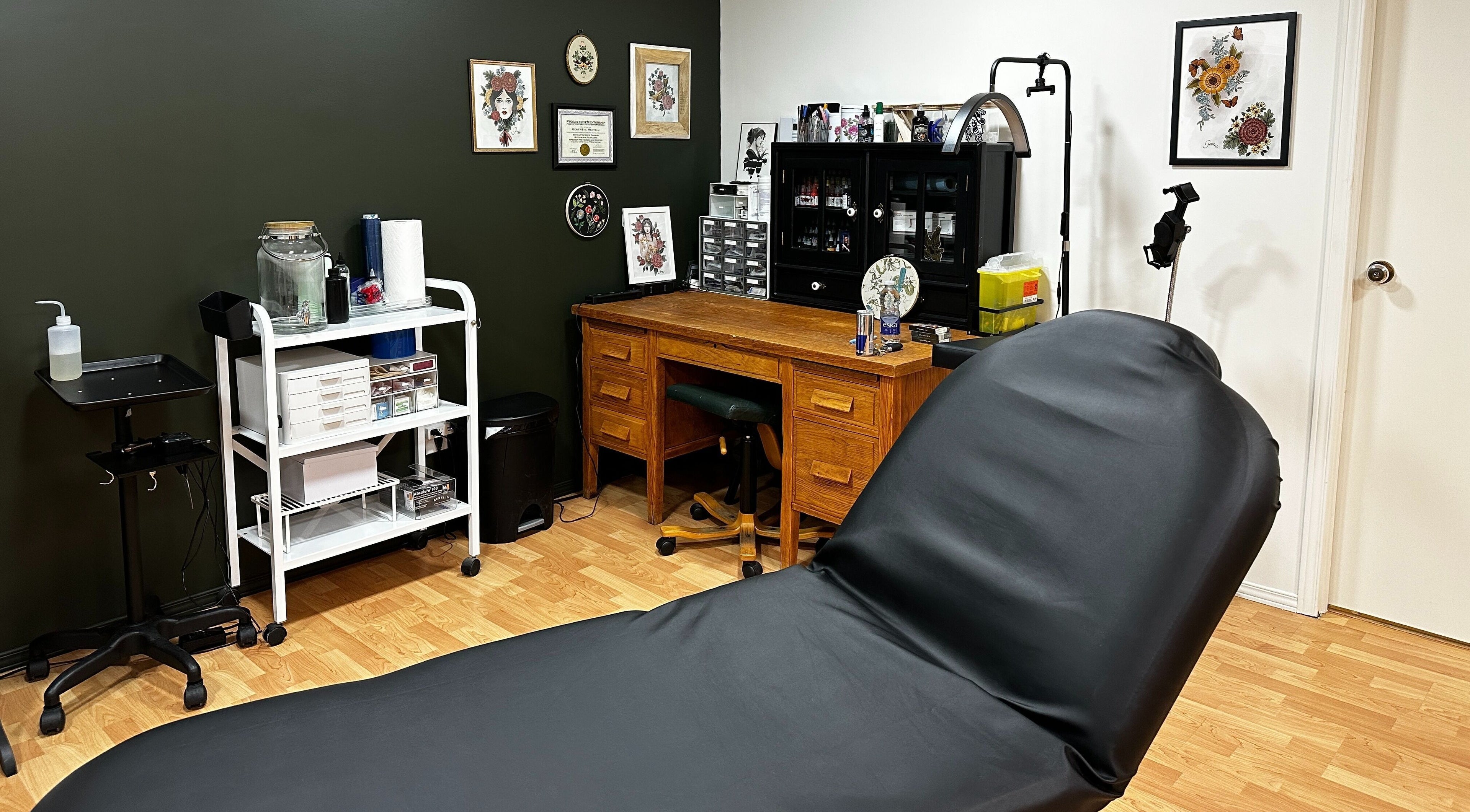 Intérieur de Tatouage Artemya à Val-d'or, Québec, CA, avec bureau en bois et chaise de tatouage.