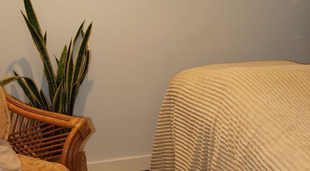 Tranquil massage room at Āio Massage And Beauty Therapy, Maraetai, Auckland, NZ featuring a comfy bed and plant.