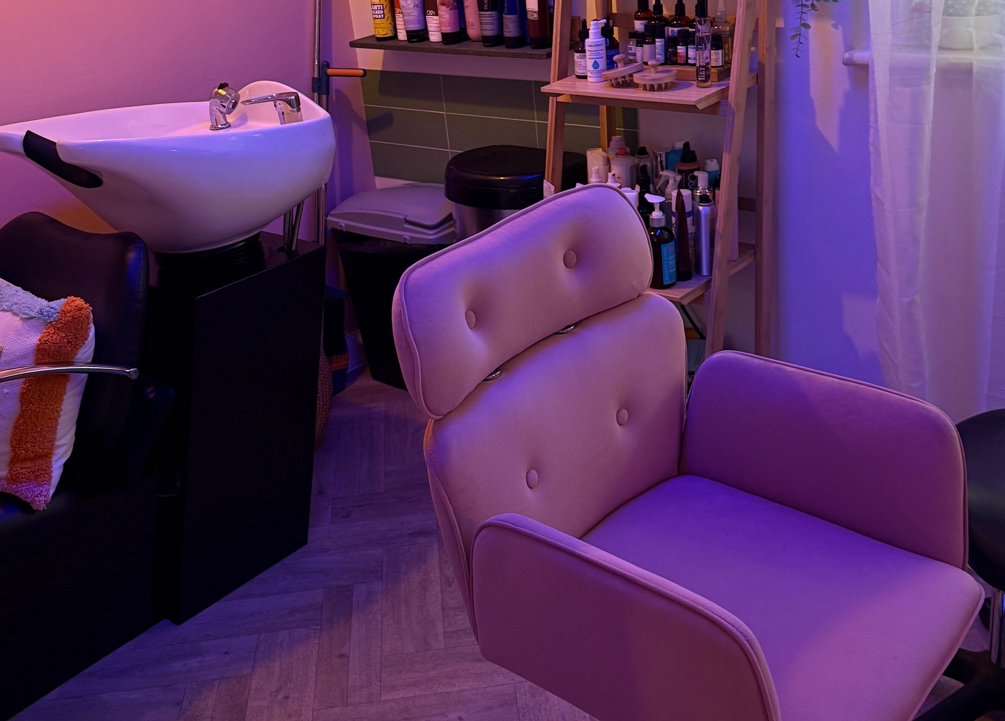 Cozy salon chair and sink setup in The Craft Hairdresser, Botley, England, GB, illuminated by soothing lavender light.