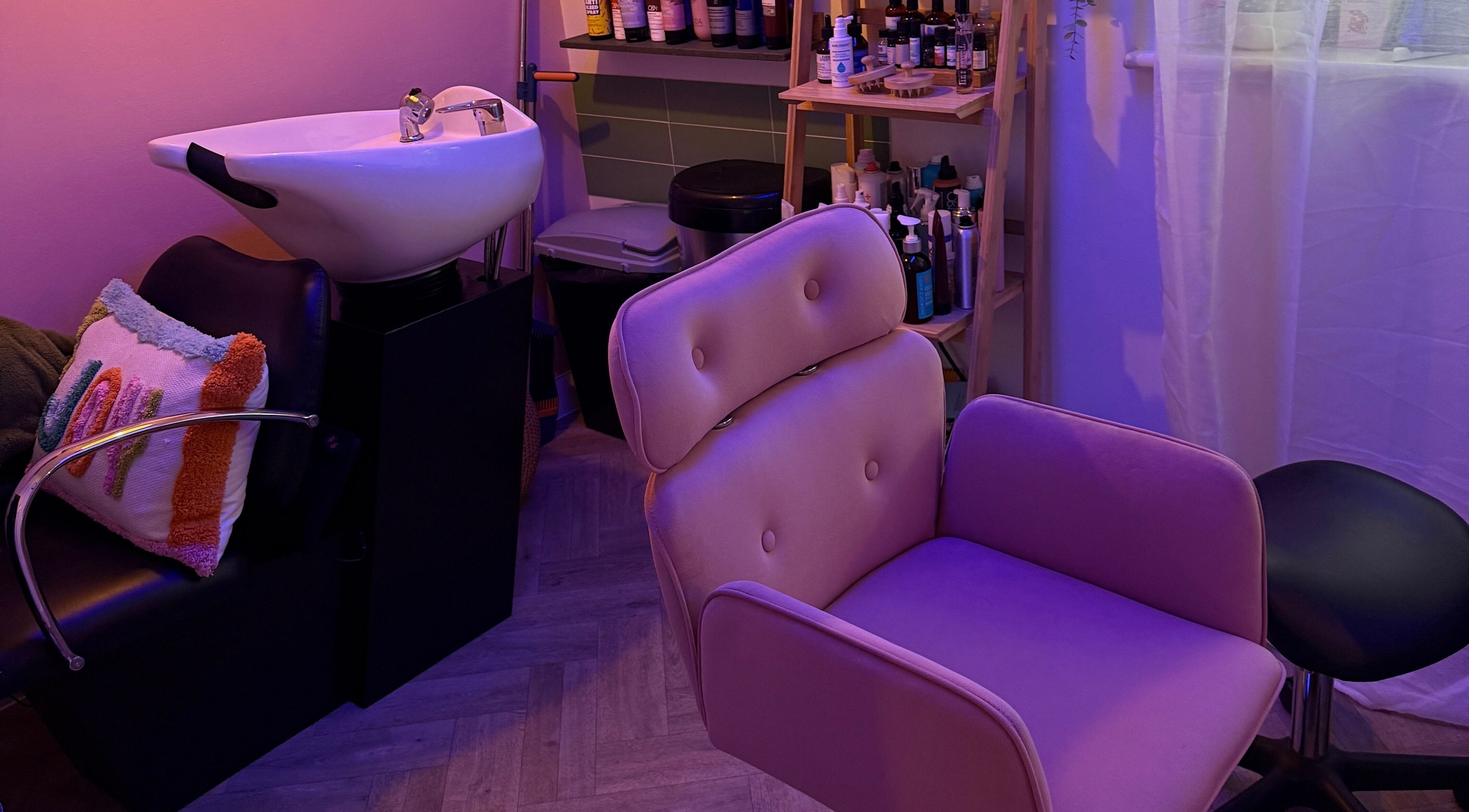 Cozy salon chair and sink setup in The Craft Hairdresser, Botley, England, GB, illuminated by soothing lavender light.