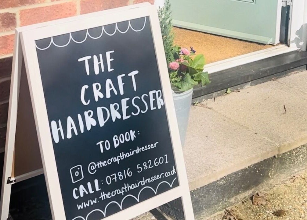 A welcoming sign at The Craft Hairdresser in Botley, England, GB, showing contact details for bookings.