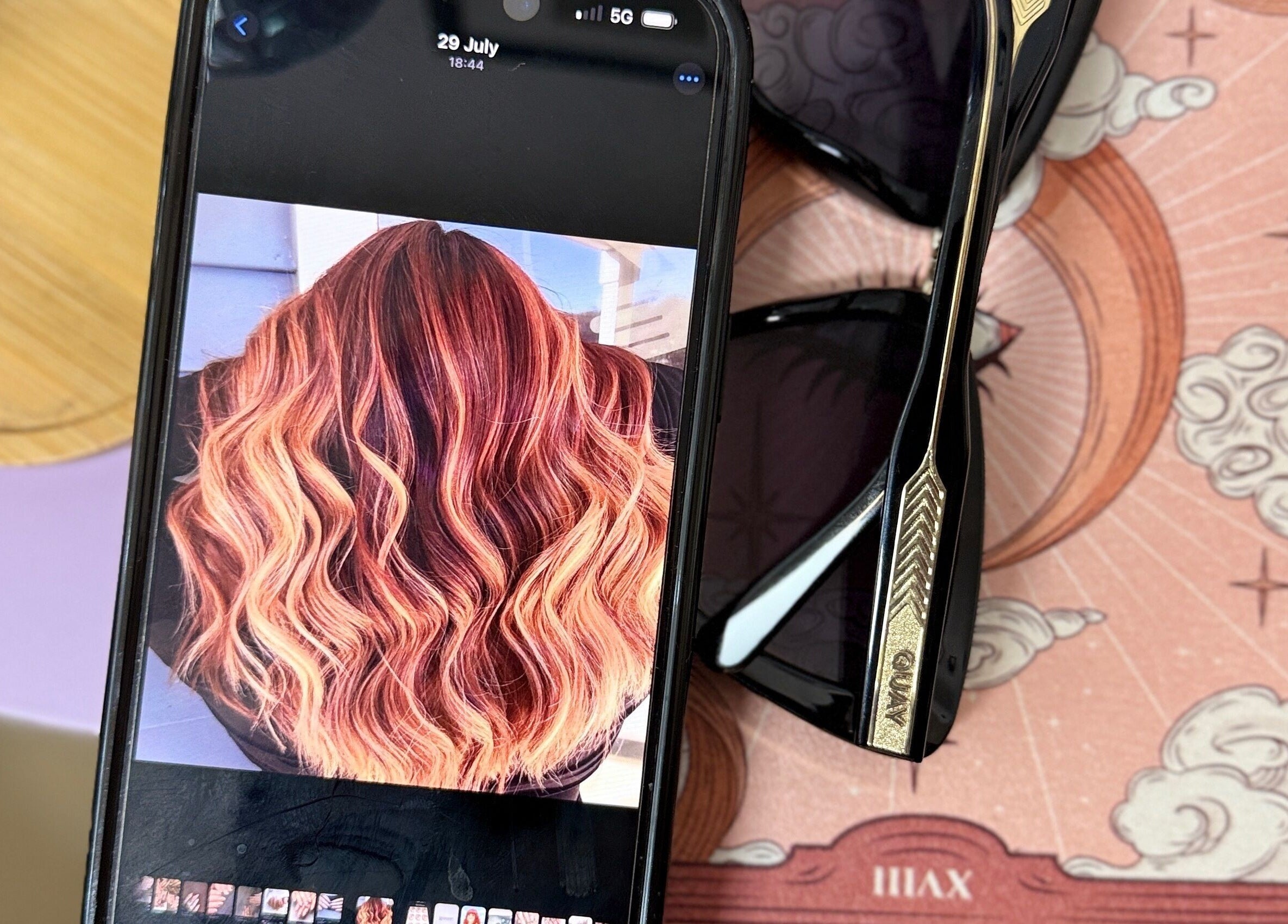 Phone displaying vibrant hair at The Craft Hairdresser, Botley, England, GB against a stylish background.