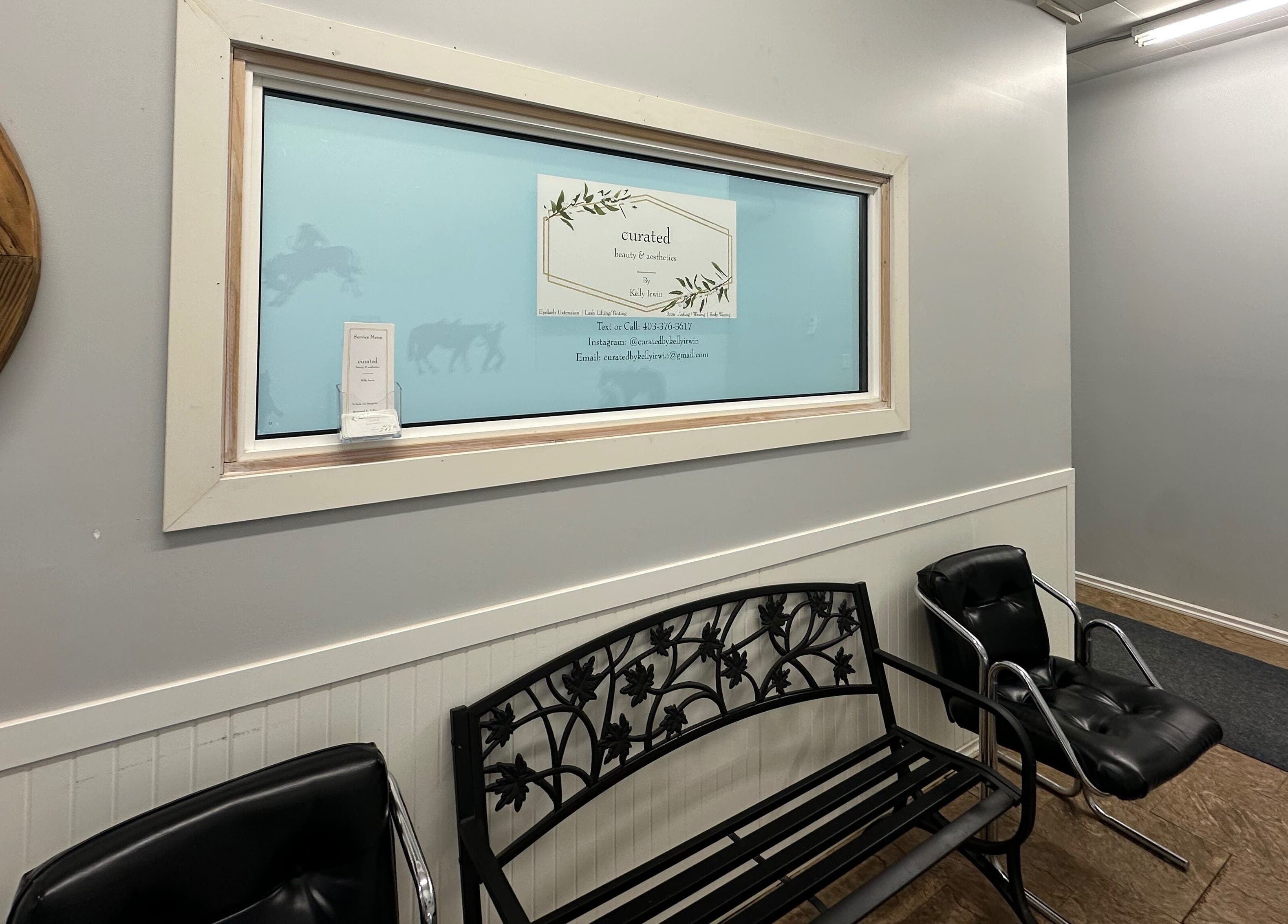 Entrance of Curated Beauty & Aesthetics in Brooks, Alberta, CA featuring stylish seating and wall decor.