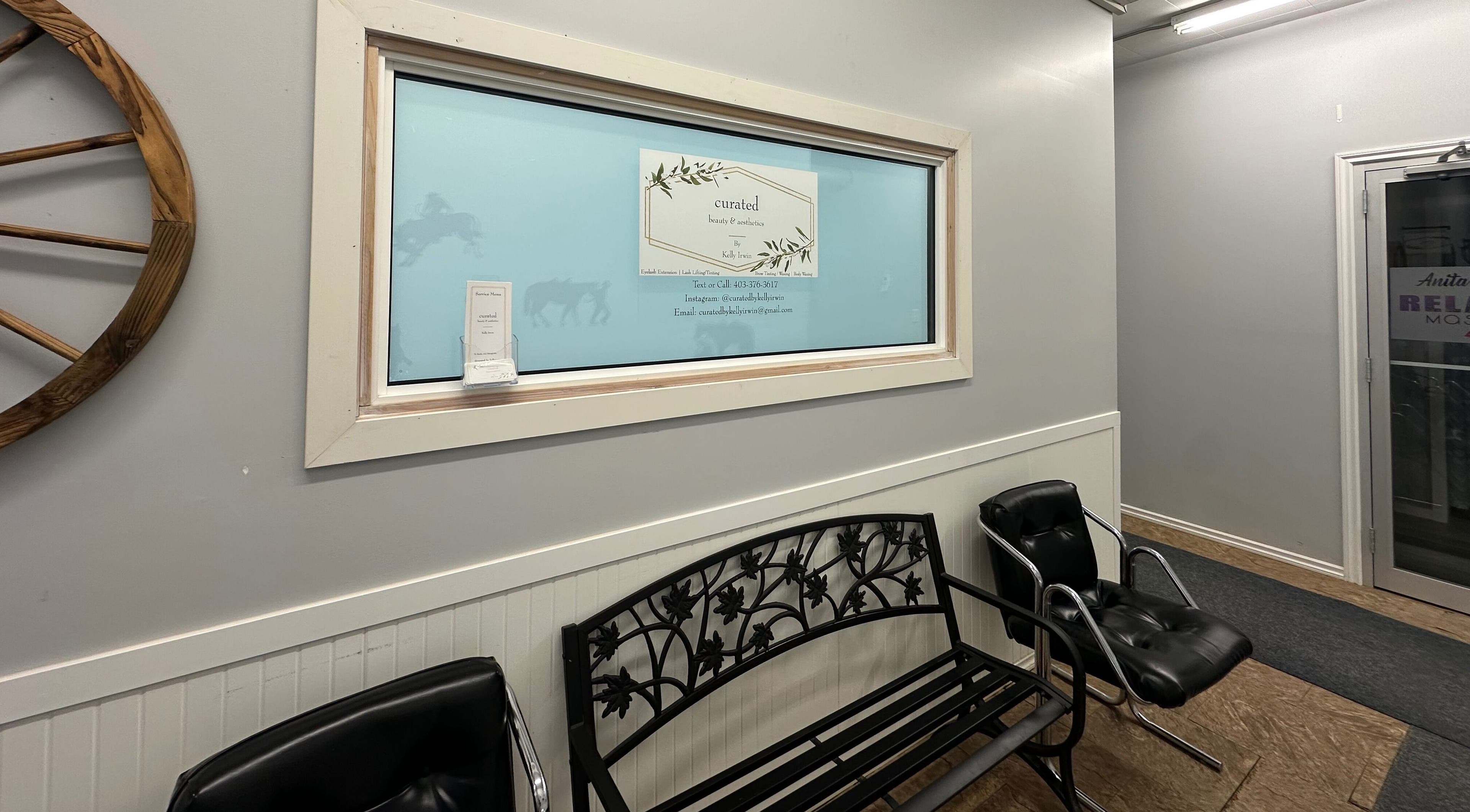 Entrance of Curated Beauty & Aesthetics in Brooks, Alberta, CA featuring stylish seating and wall decor.