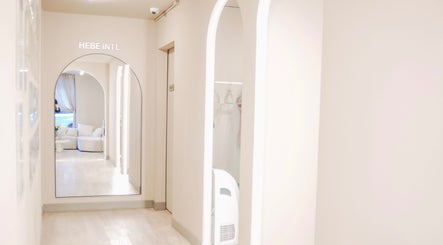 Chic interior hallway at HELA Skincare- SoHo in New York, New York, US with stylish mirrors and a cozy seating area.
