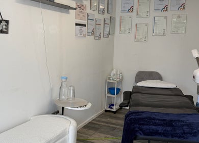 Treatment room with certificates at 19 Beauty Room, Leigh, England, GB, showcasing professional setup.