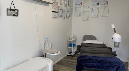 Treatment room with certificates at 19 Beauty Room, Leigh, England, GB, showcasing professional setup.