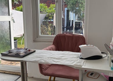 Cozy nail station at 19 Beauty Room in Leigh, England, GB, with view of a lush garden.