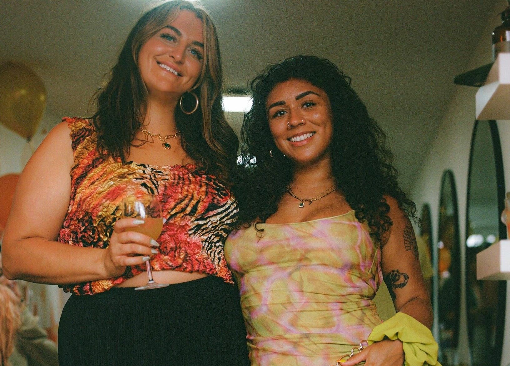 Two women smiling at Barnet Fair, London, England, GB, enjoying a vibrant and uplifting atmosphere.