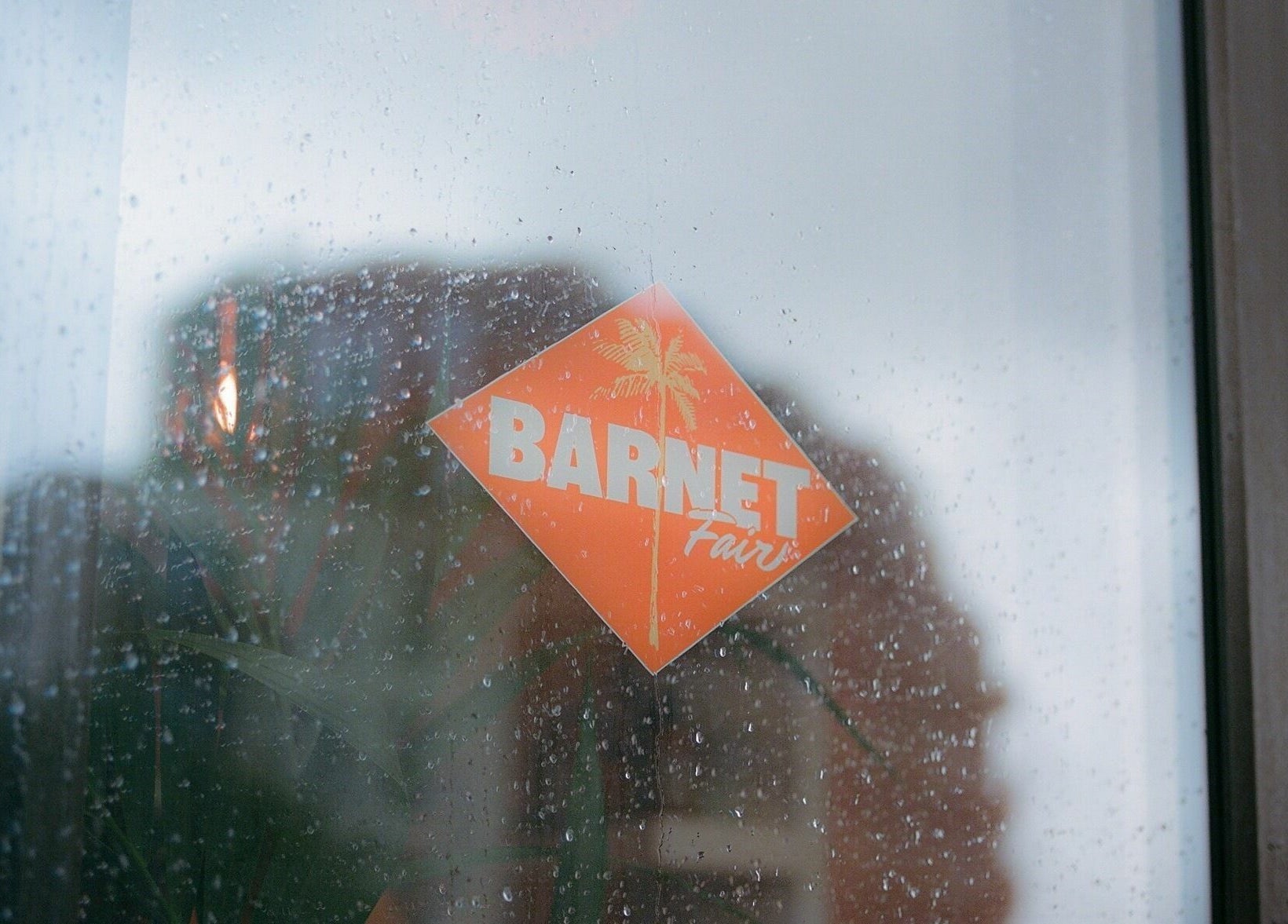 Barnet Fair logo on a rainy window at London, England, GB, reflecting a cozy interior ambiance.