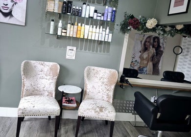 Stylish seating and hair products at Affinity Hair Design, Waddesdon, England, GB, showcasing a cozy salon space.