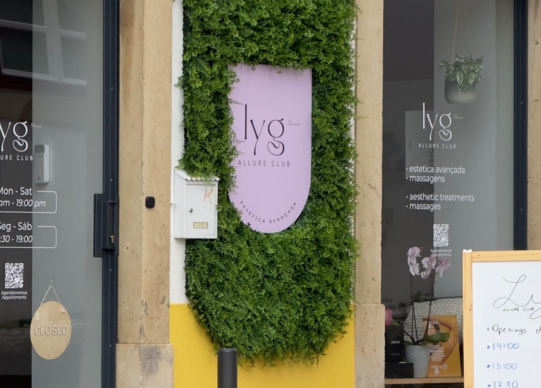 Entrada de Lyg Allure Club by Amanda - Estética Avançada em Tomar, Santarém, PT, com placa e vegetação.