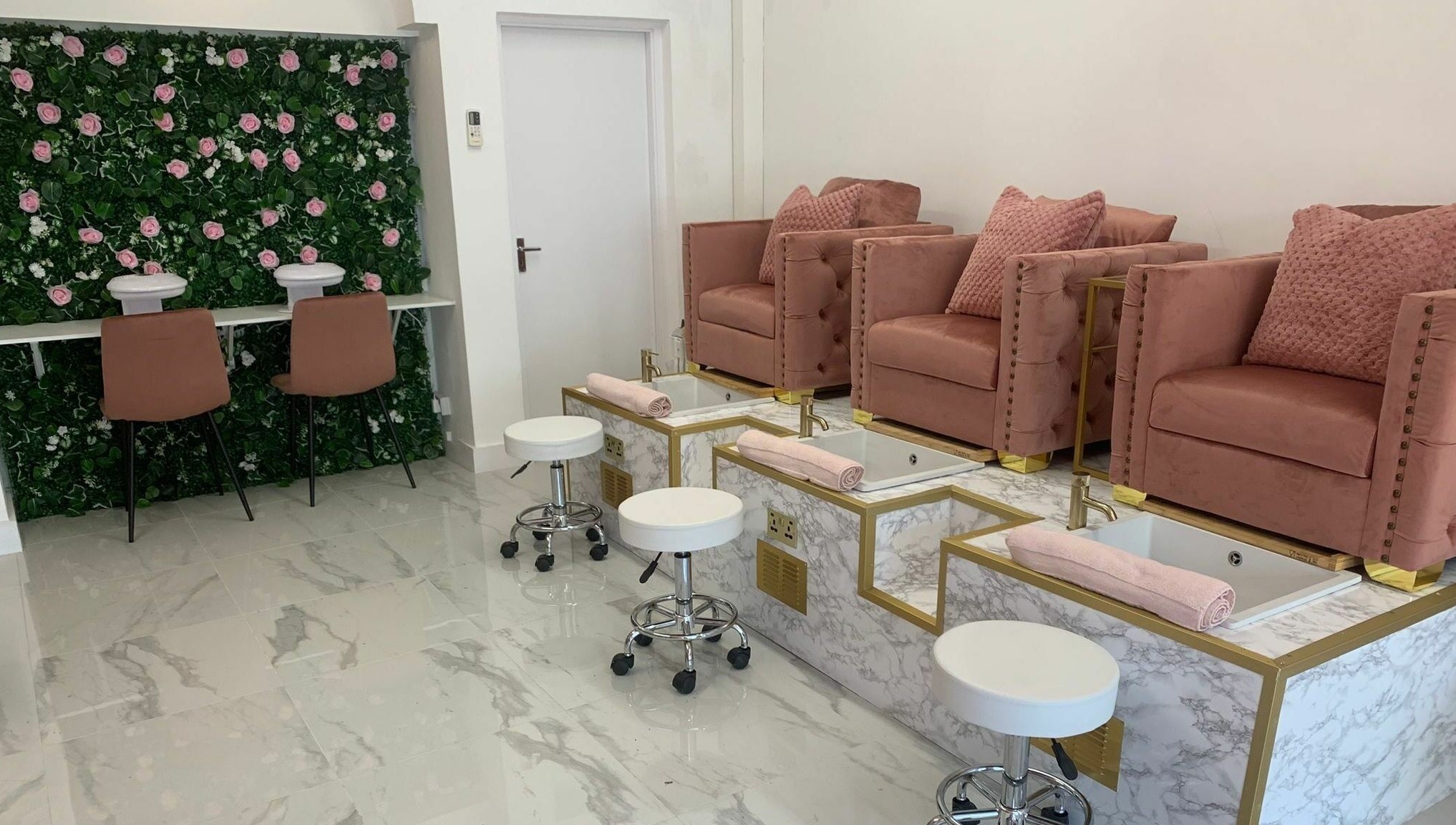 Luxurious Glam Studio nail salon in Erith, England, GB with plush pink chairs and floral decor.