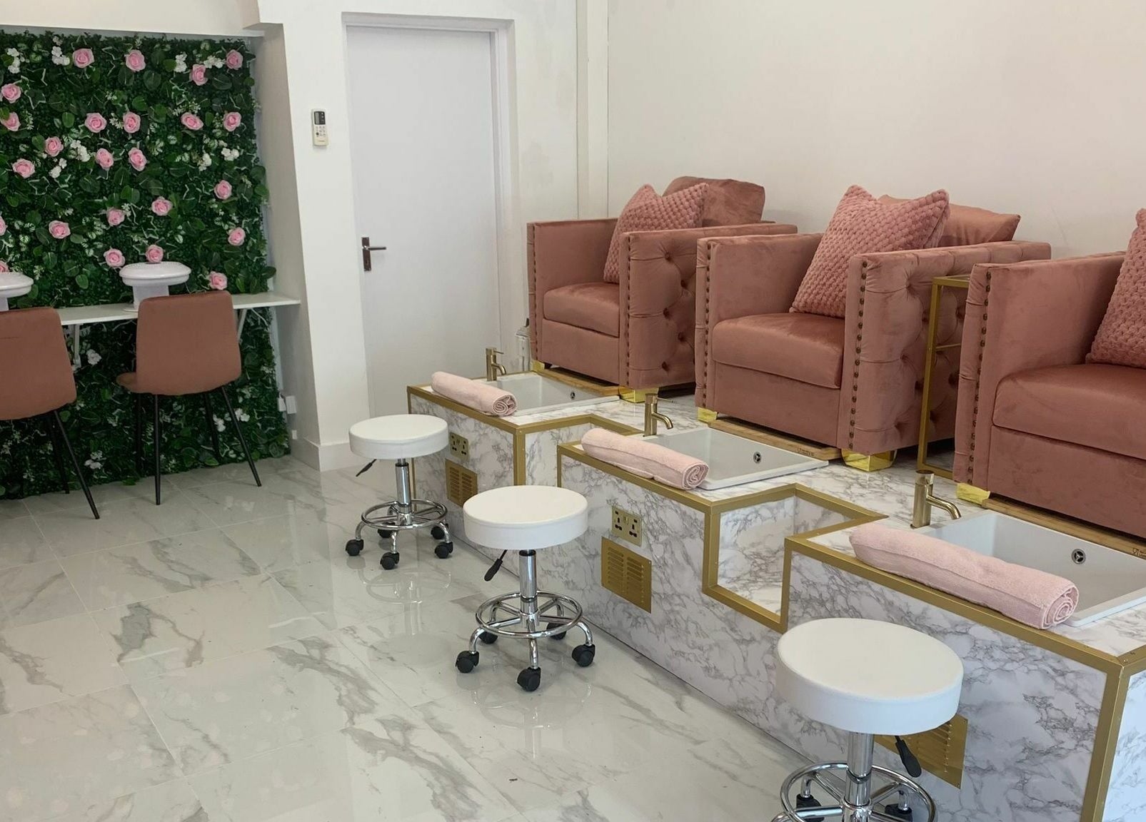 Luxurious Glam Studio nail salon in Erith, England, GB with plush pink chairs and floral decor.