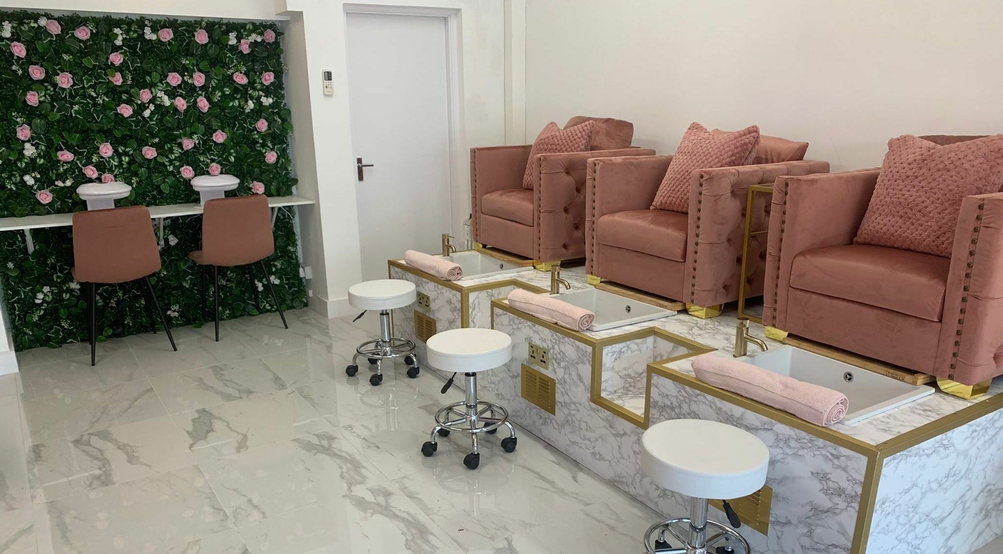Luxurious Glam Studio nail salon in Erith, England, GB with plush pink chairs and floral decor.