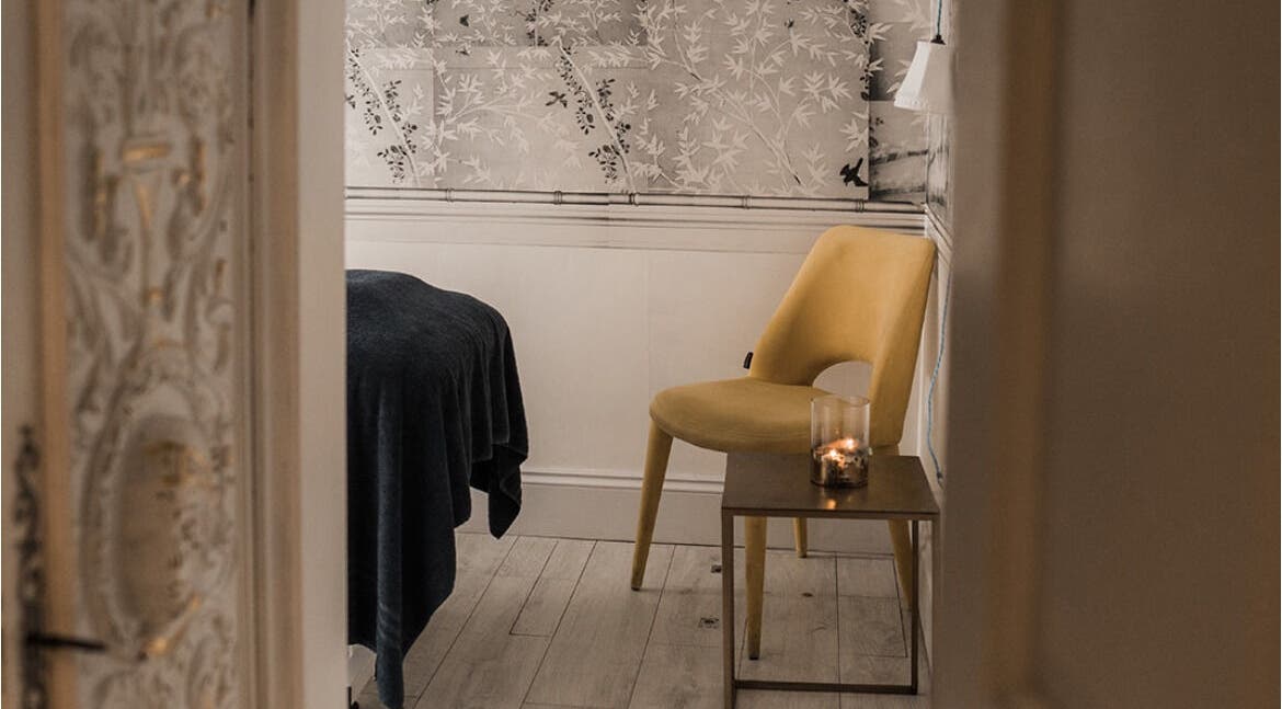 Elegant Treatment Rooms in Hastings, England, GB featuring a cozy setup with a candlelit table and chair.