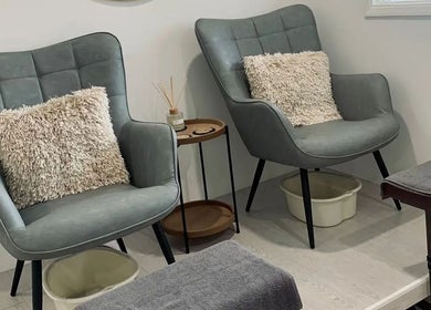 Relaxing seating area for pedicures at Phoenix Beauty, Maidstone, England, GB. Plush chairs and soft lighting.