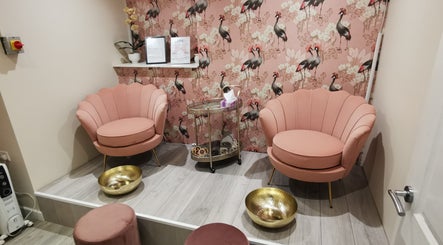 Elegant lounge at Vanity, Leicester, England, GB with pink chairs, golden bowls, and bird-patterned decor.