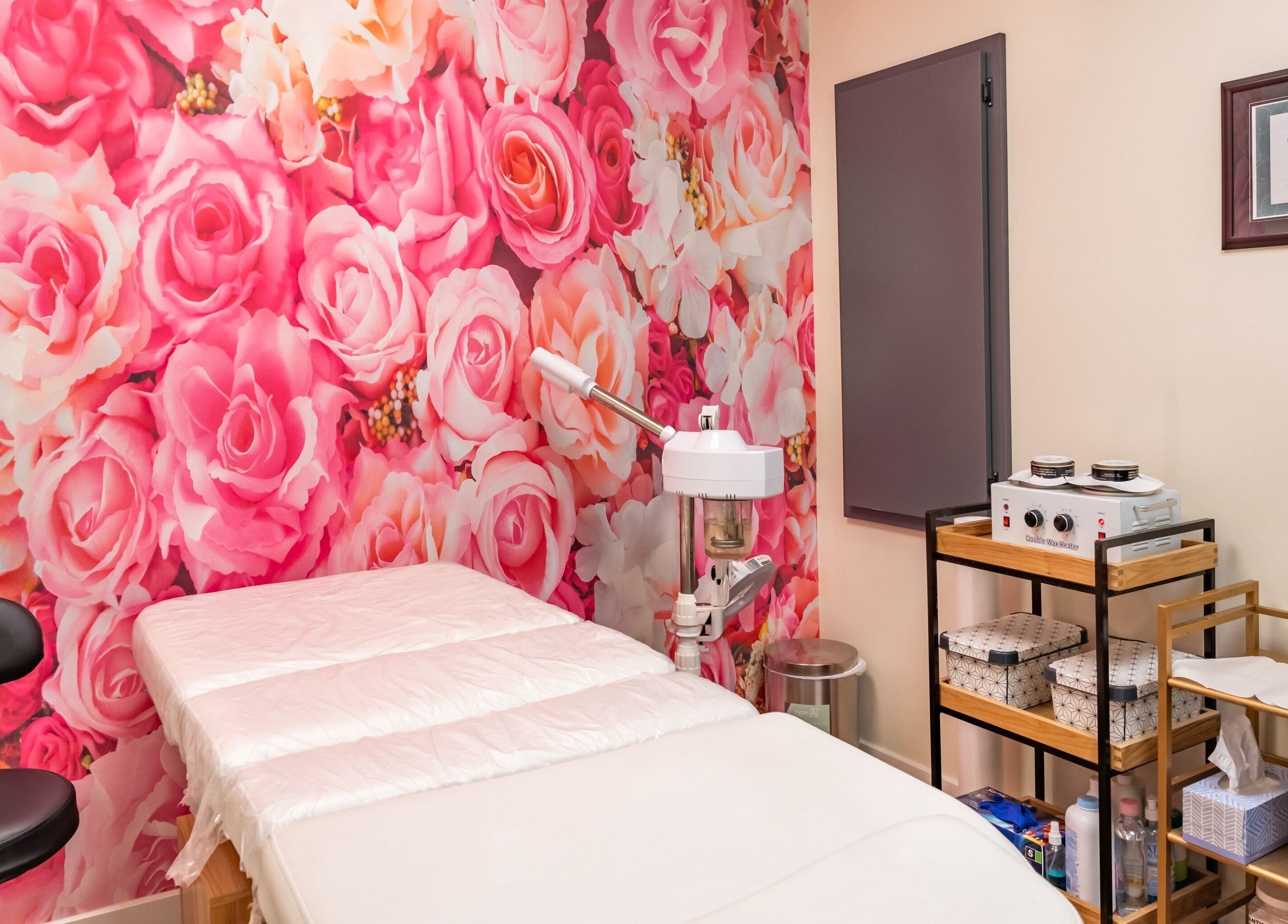 Namaste Beauty massage room with pink floral wall, located at Maple Ridge #330, British Columbia, CA.