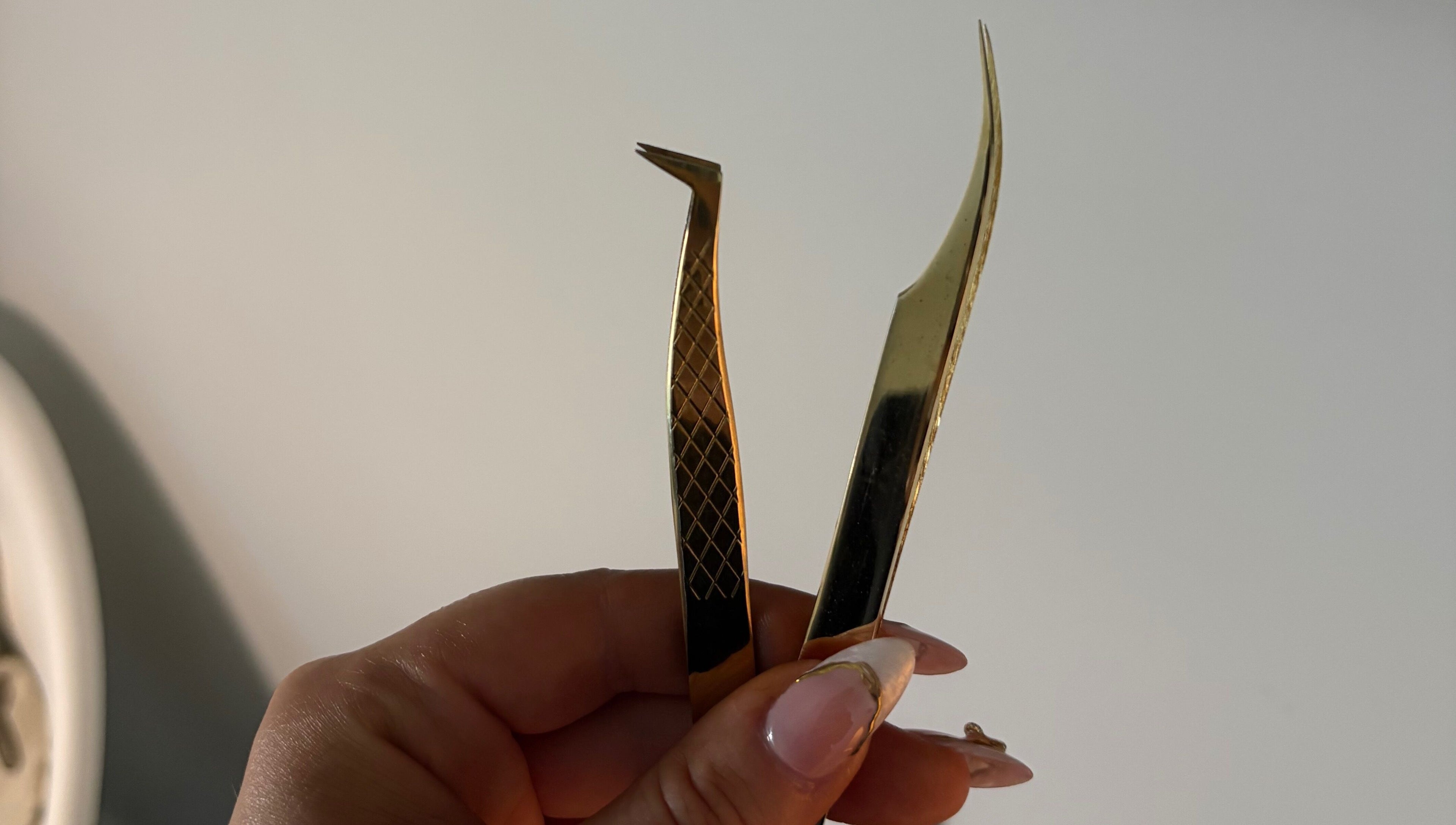 Elegant gold tweezers at Aesthetics by Amie, Calgary, Alberta, CA for precise beauty treatments.
