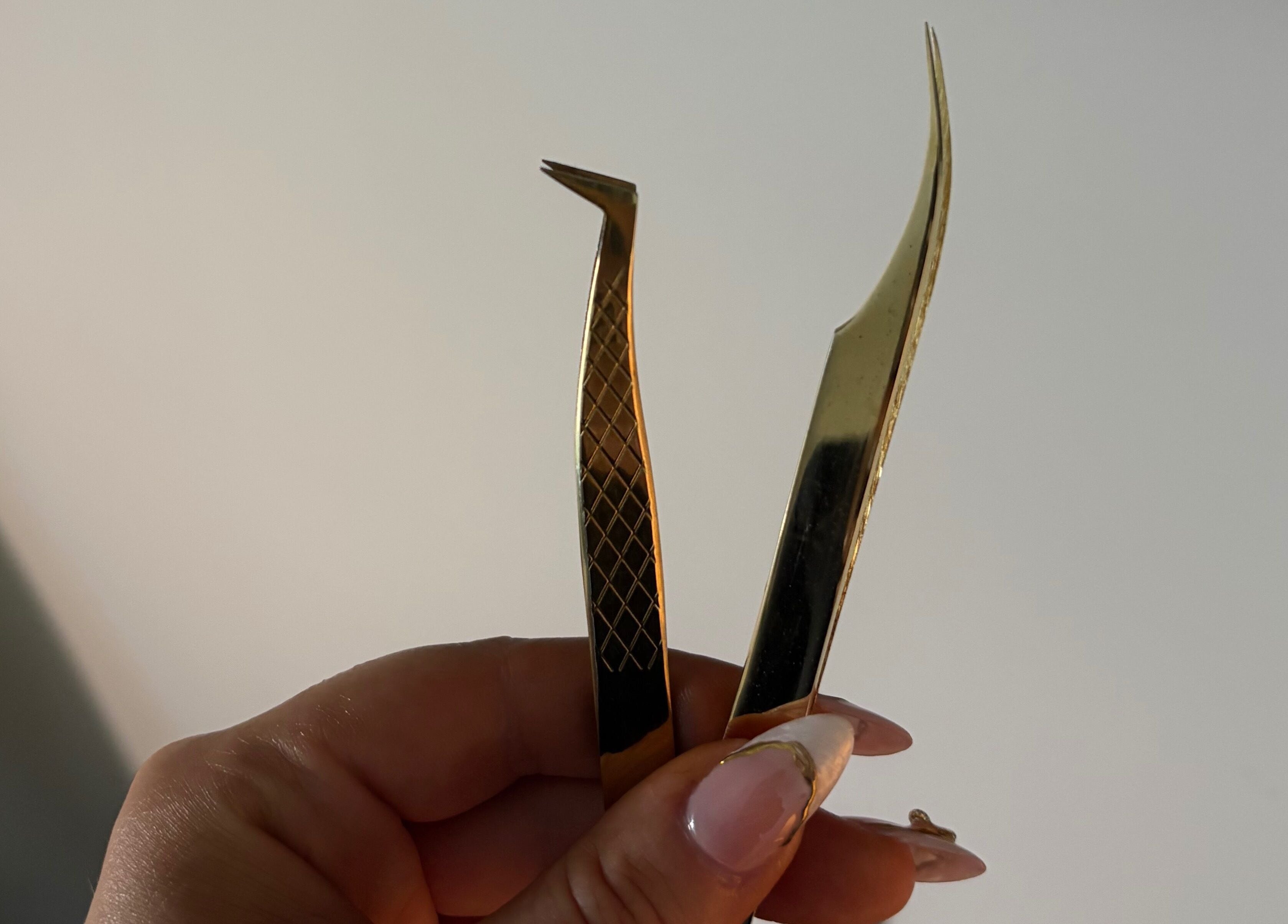 Elegant gold tweezers at Aesthetics by Amie, Calgary, Alberta, CA for precise beauty treatments.