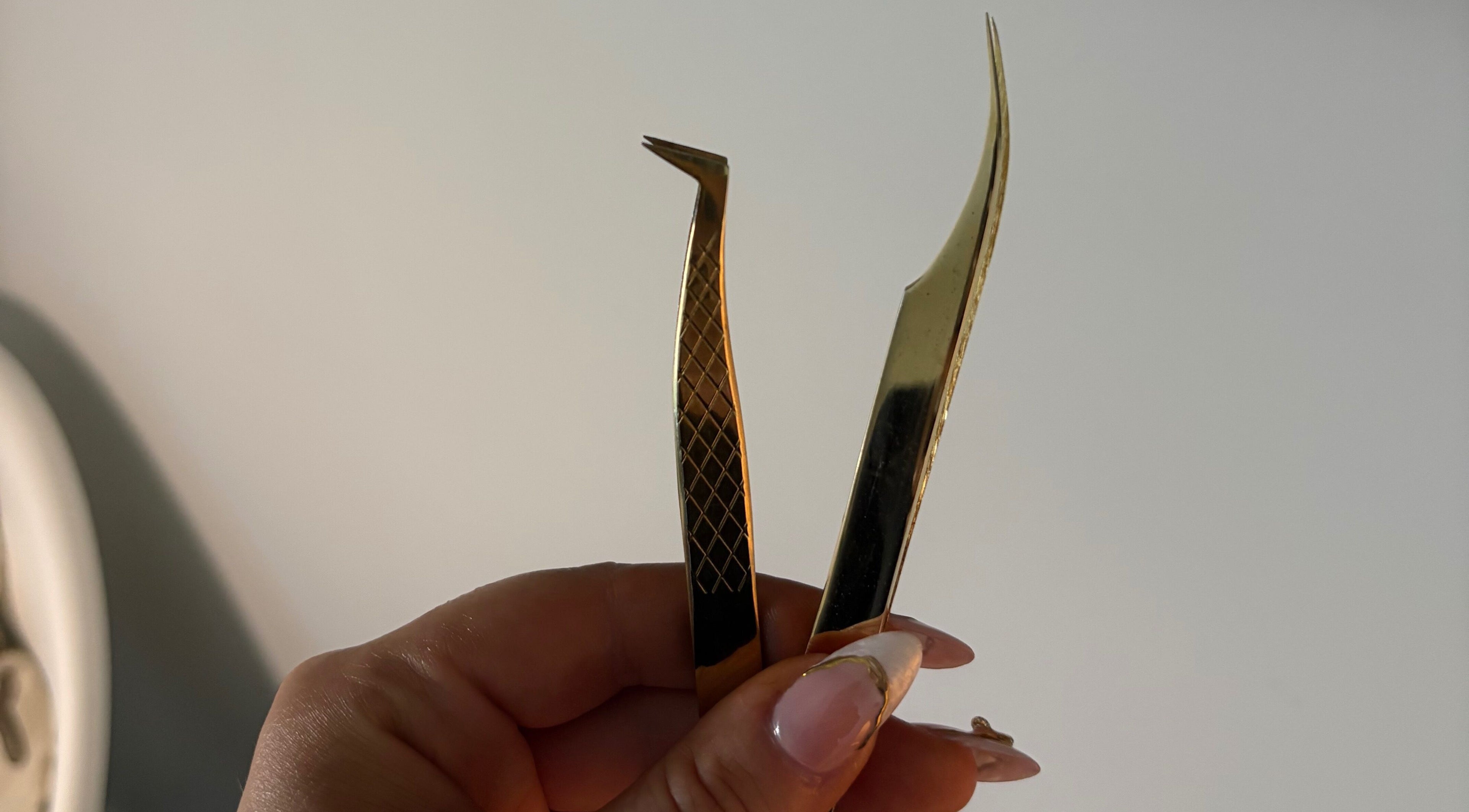 Elegant gold tweezers at Aesthetics by Amie, Calgary, Alberta, CA for precise beauty treatments.