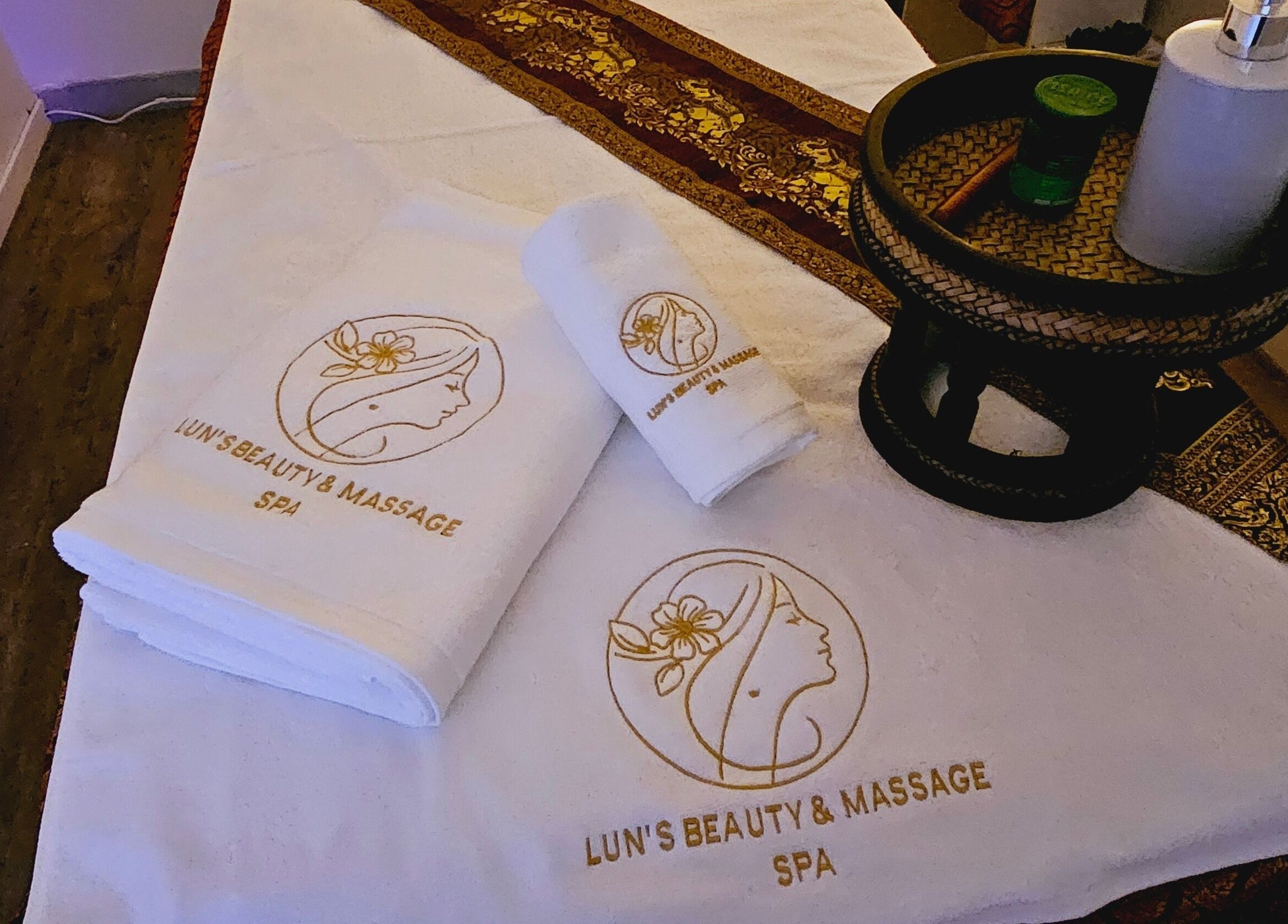 Elegant massage setup at Lun's Beauty and Massage Spa, Redcliffe, Queensland, AU, with branded towels.