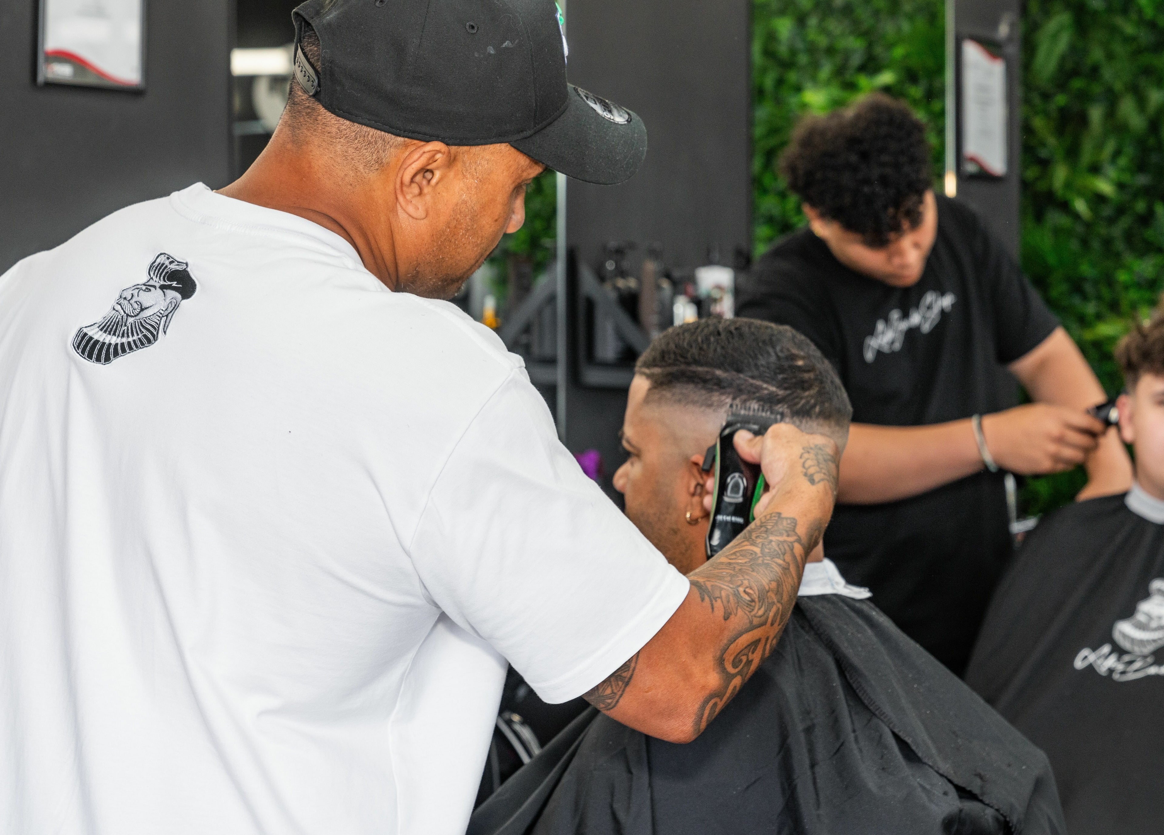 Barber expertly cutting hair at Lole's Barber Shop - Commercial Drive, Springfield, Queensland, AU.