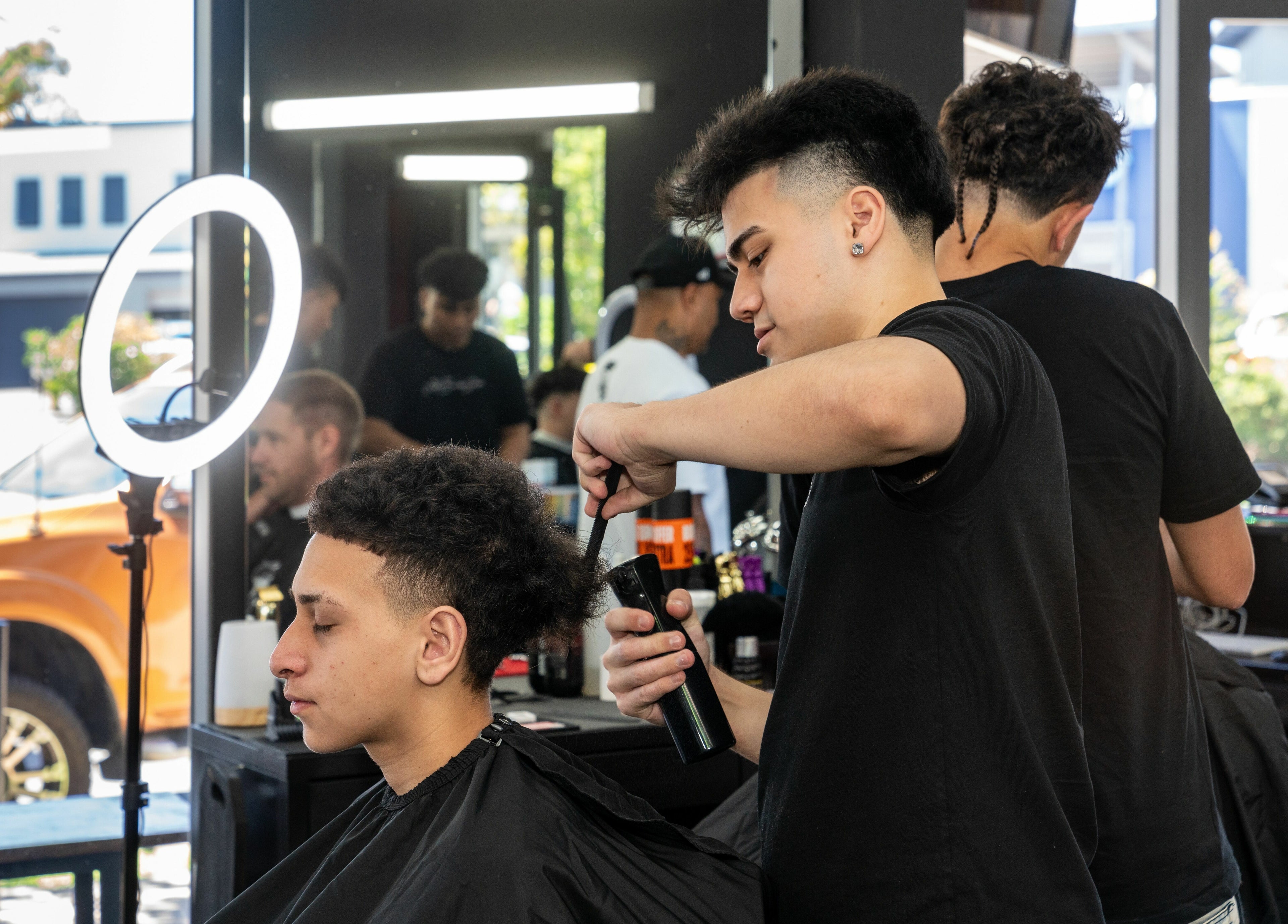 Lole's Barber Shop - Commercial Drive, Springfield, Queensland, AU: barber styling a client's hair.