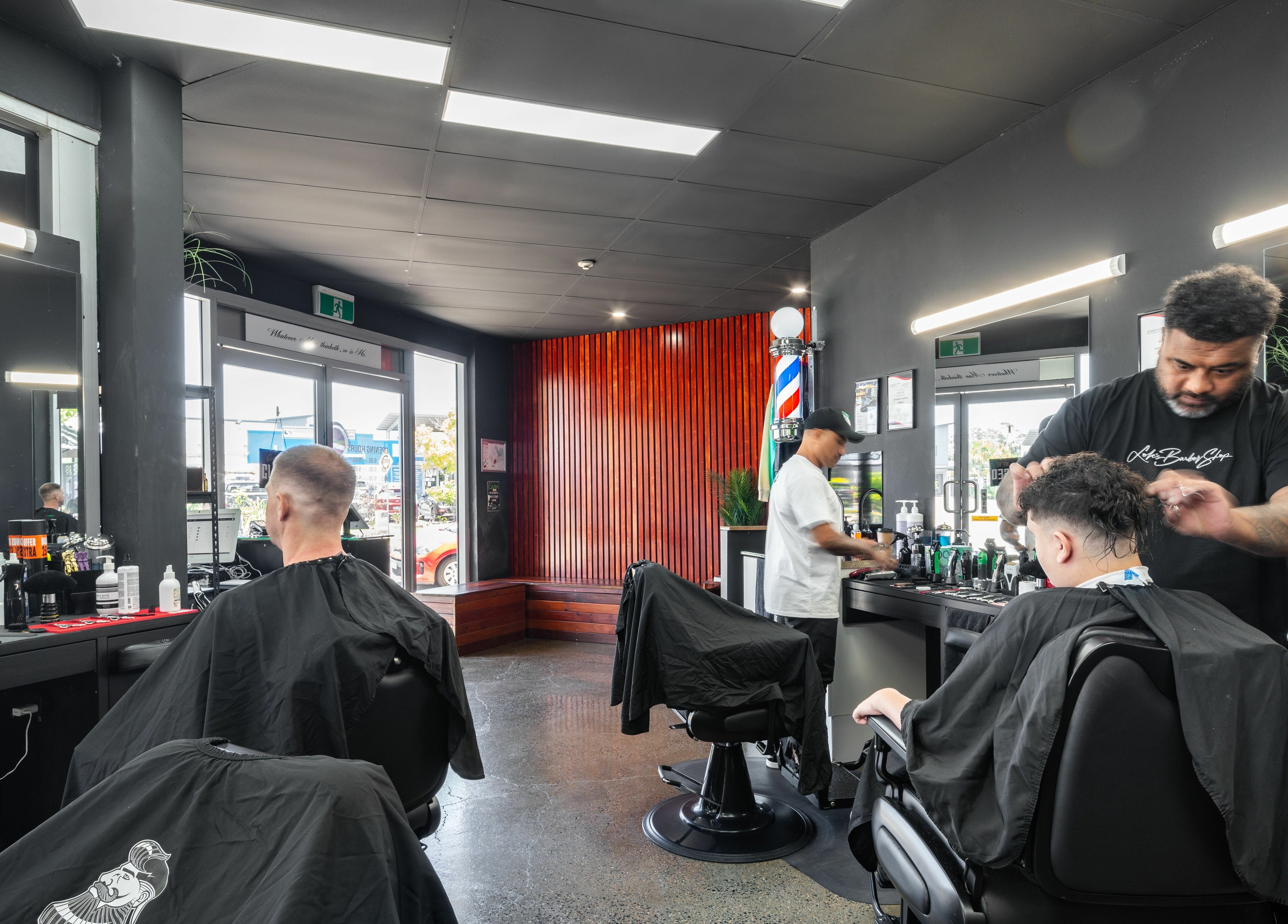 Interior of Lole's Barber Shop - Commercial Drive, Springfield, Queensland, AU with customers and barbers at work.