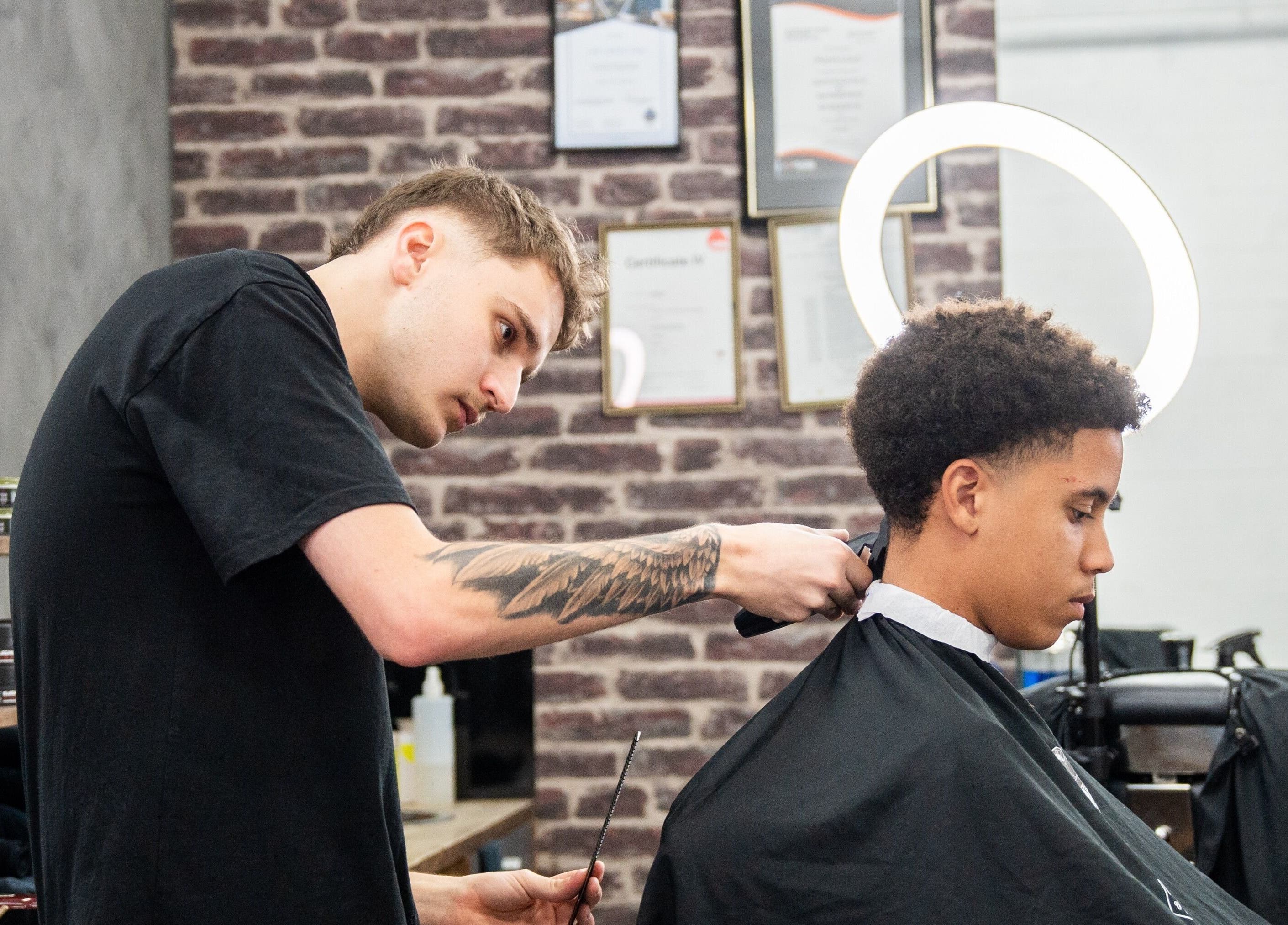 Stylist at Lole's Barber Shop - Ian Keilar Drive, Springfield Central, QLD, AU giving a haircut.