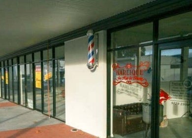 Front view of Doin Just Fine - Fine Line Tattoo in Bentley, Western Australia, AU with glass windows and barber pole.