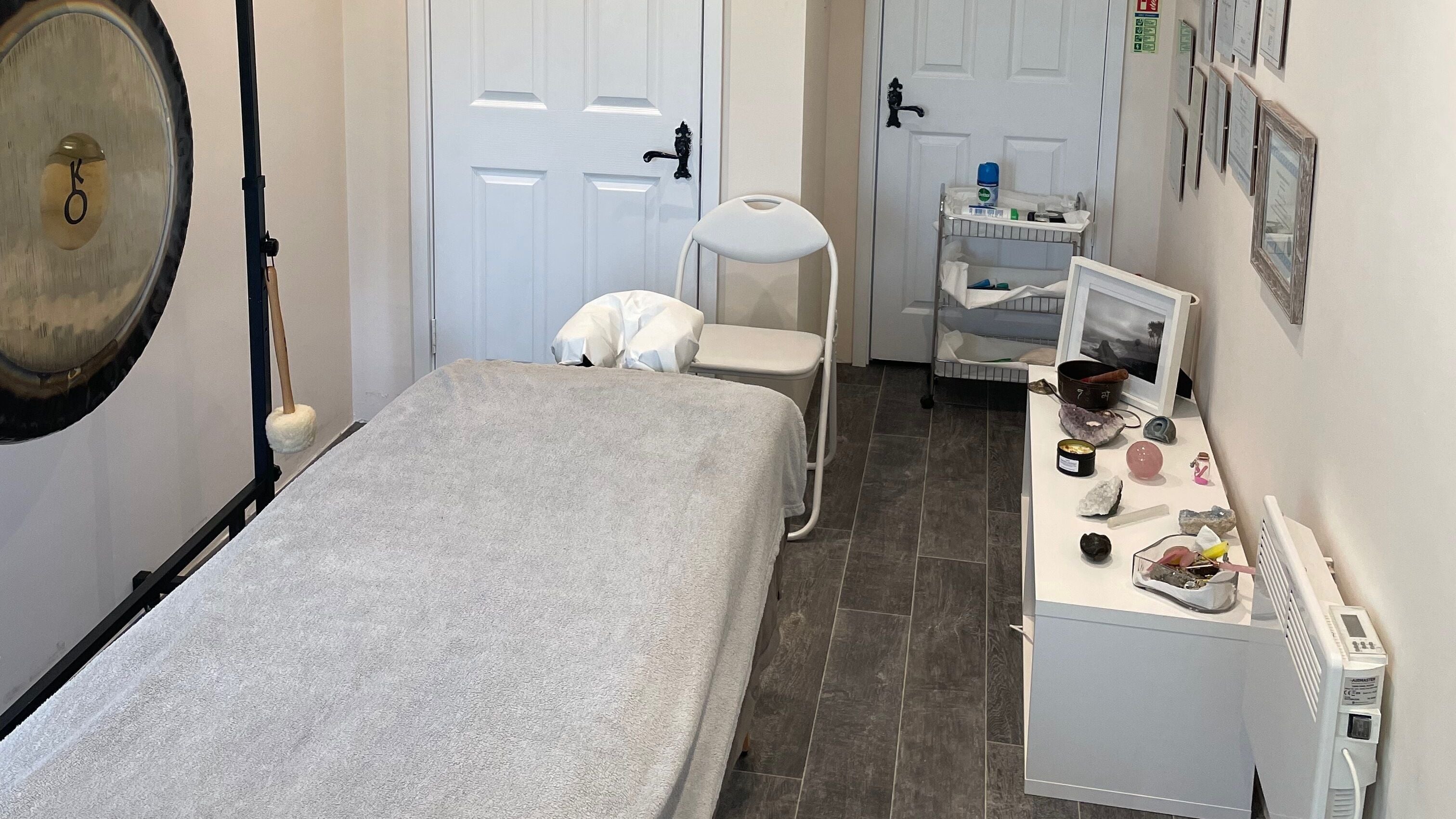 Calming therapy room at Farnborough ART of Healing, featuring a massage table and gong. Farnborough, England, GB.