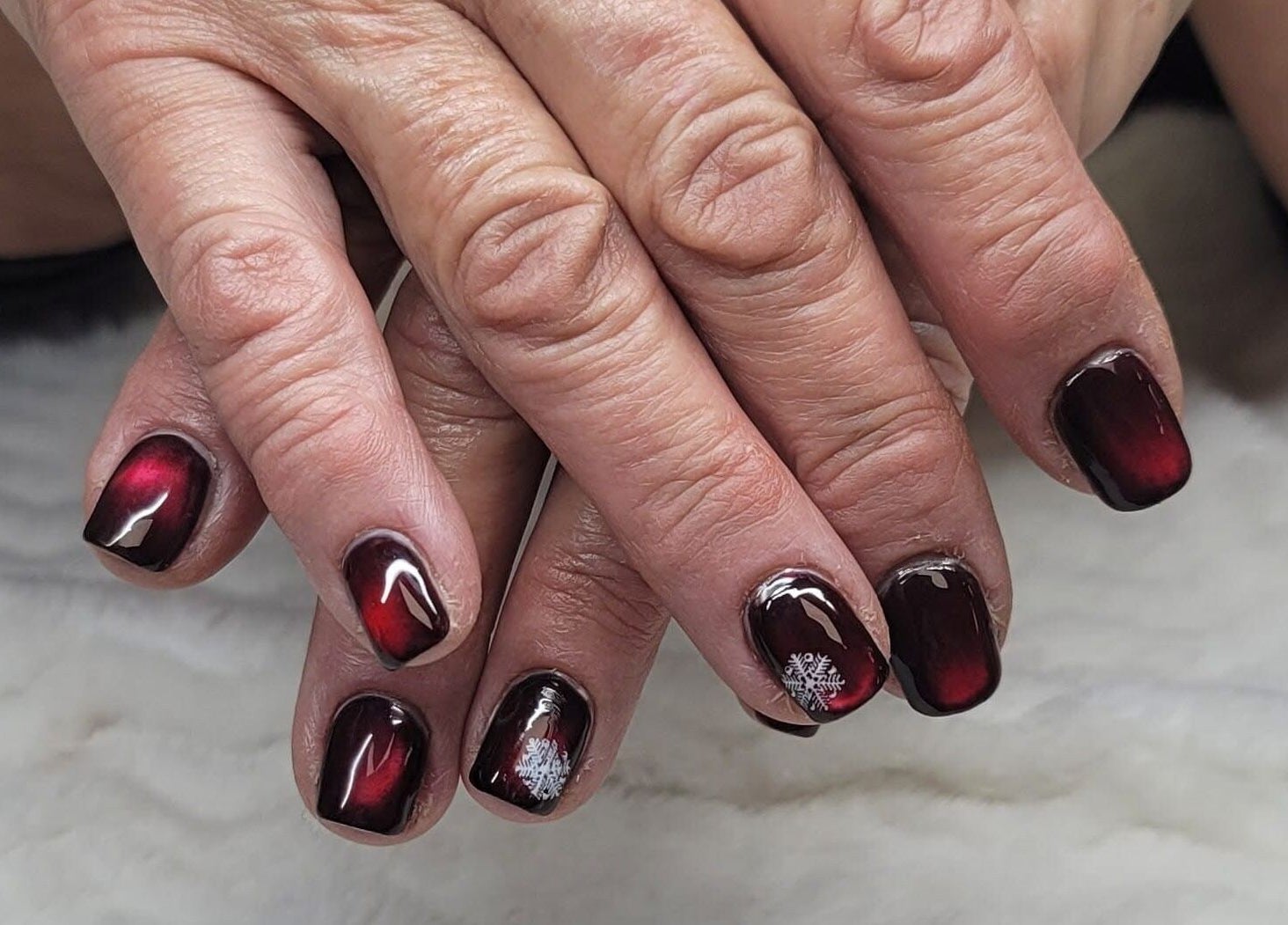 Intricate red nail art with snowflake design at Erica's Salon & Spa, Monterey, Tennessee, US.