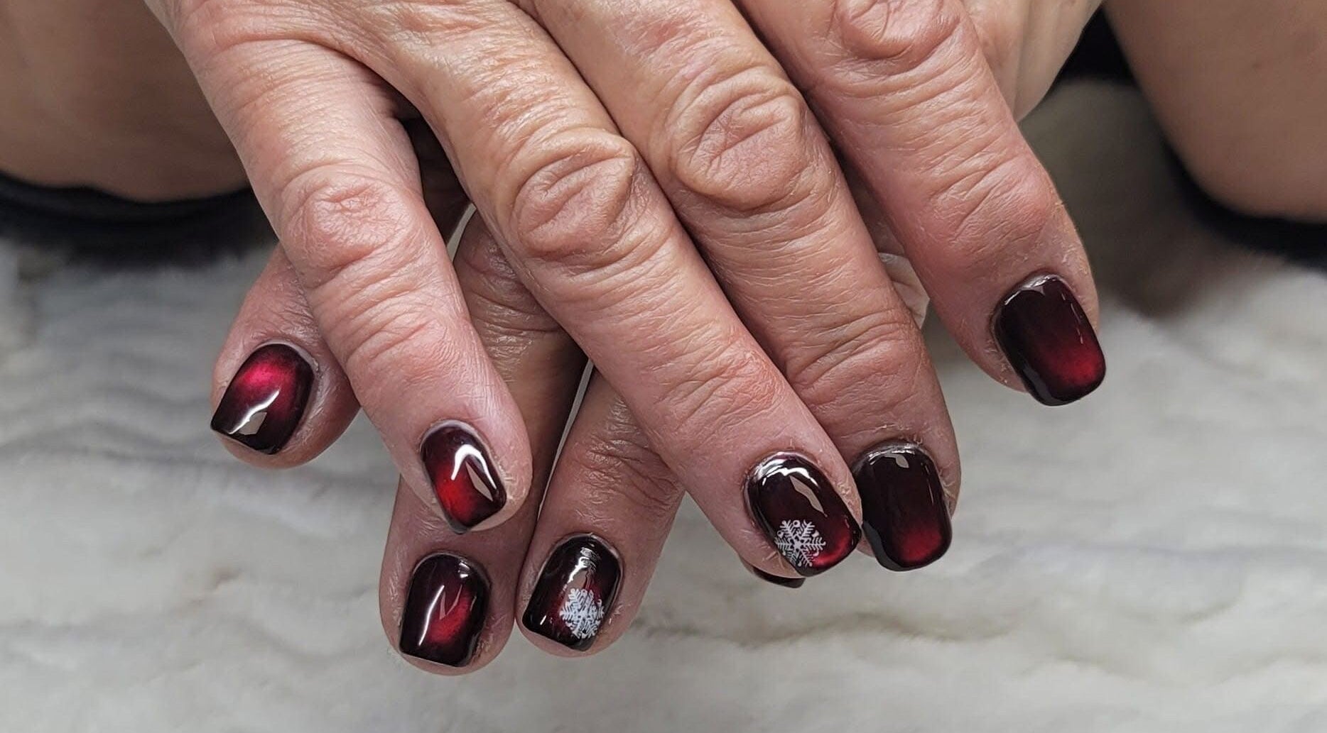 Intricate red nail art with snowflake design at Erica's Salon & Spa, Monterey, Tennessee, US.