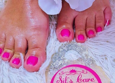 Bright pink toenails freshly done at Sils Care For You in Kralendijk, Bonaire, BQ on soft white mat.