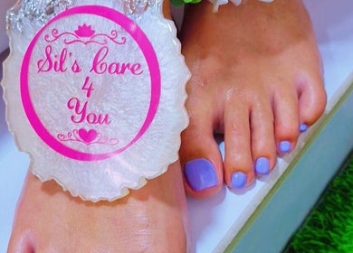 Elegant pedicure at Sils Care For You, Kralendijk, Bonaire, BQ. Vibrant lavender nails showcased with logo.