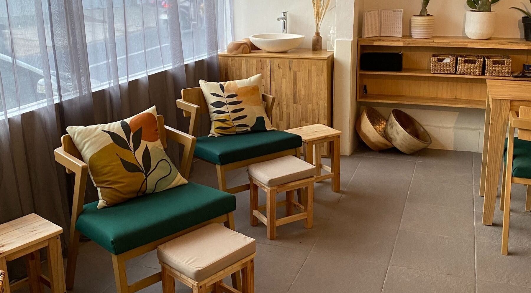 Cozy seating area at Lush Bali Beauty Salon, Bali, ID, featuring wooden chairs and stylish cushions.