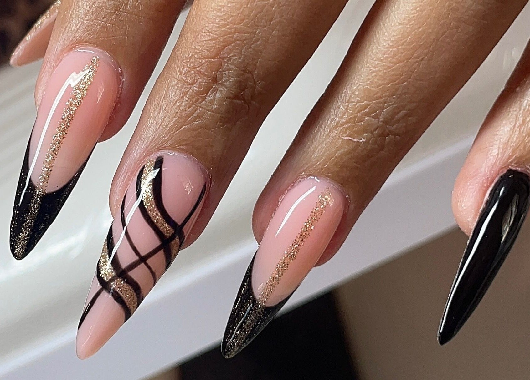 Nail art élégante chez Mily Beauty Concept à Cayenne, Arrondissement De Cayenne, GF, avec des motifs noirs et dorés.