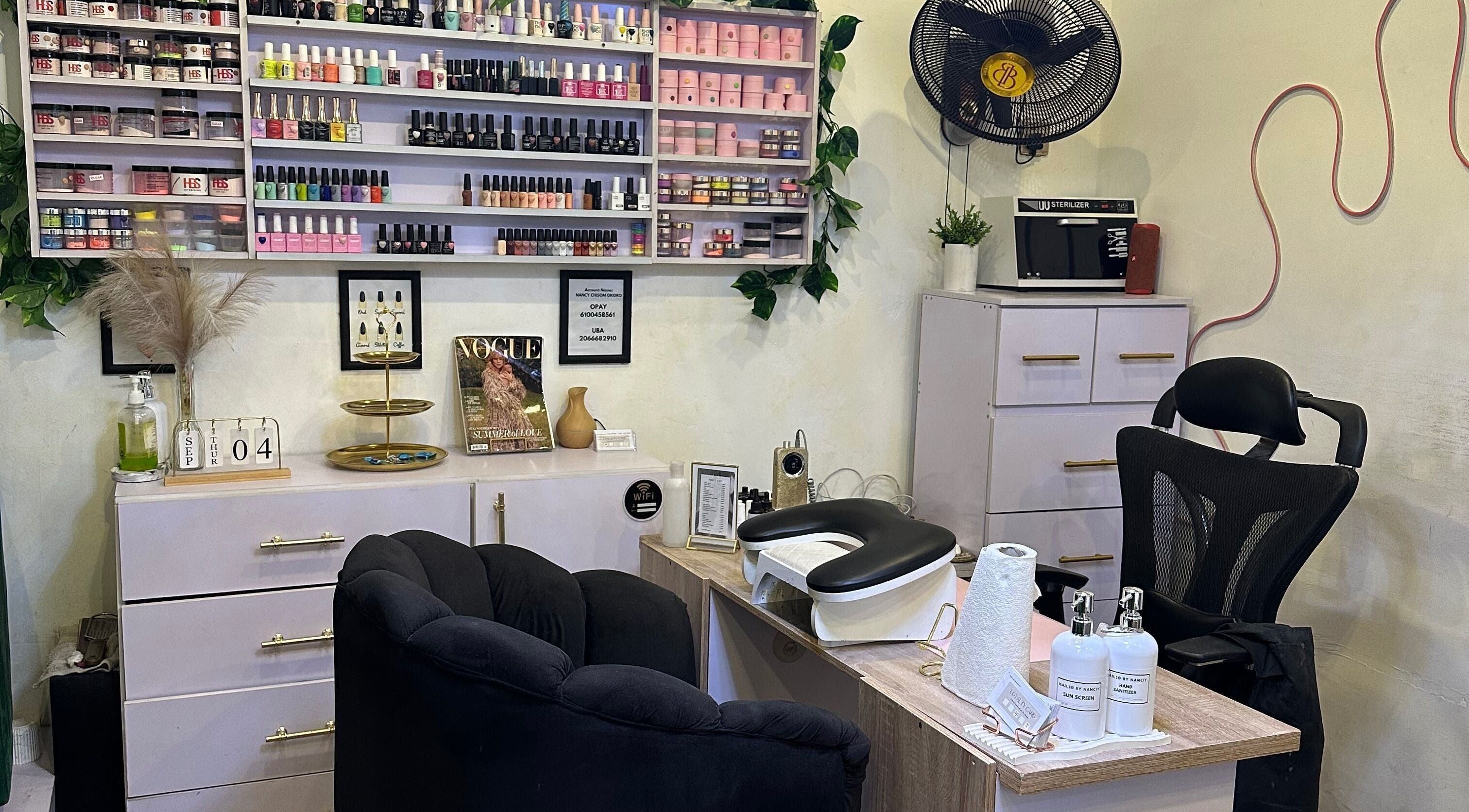 Chic nail salon setup at Nailed by Nanciy, Port Harcourt, Rivers, NG. Stylish shelves with vibrant nail polishes.