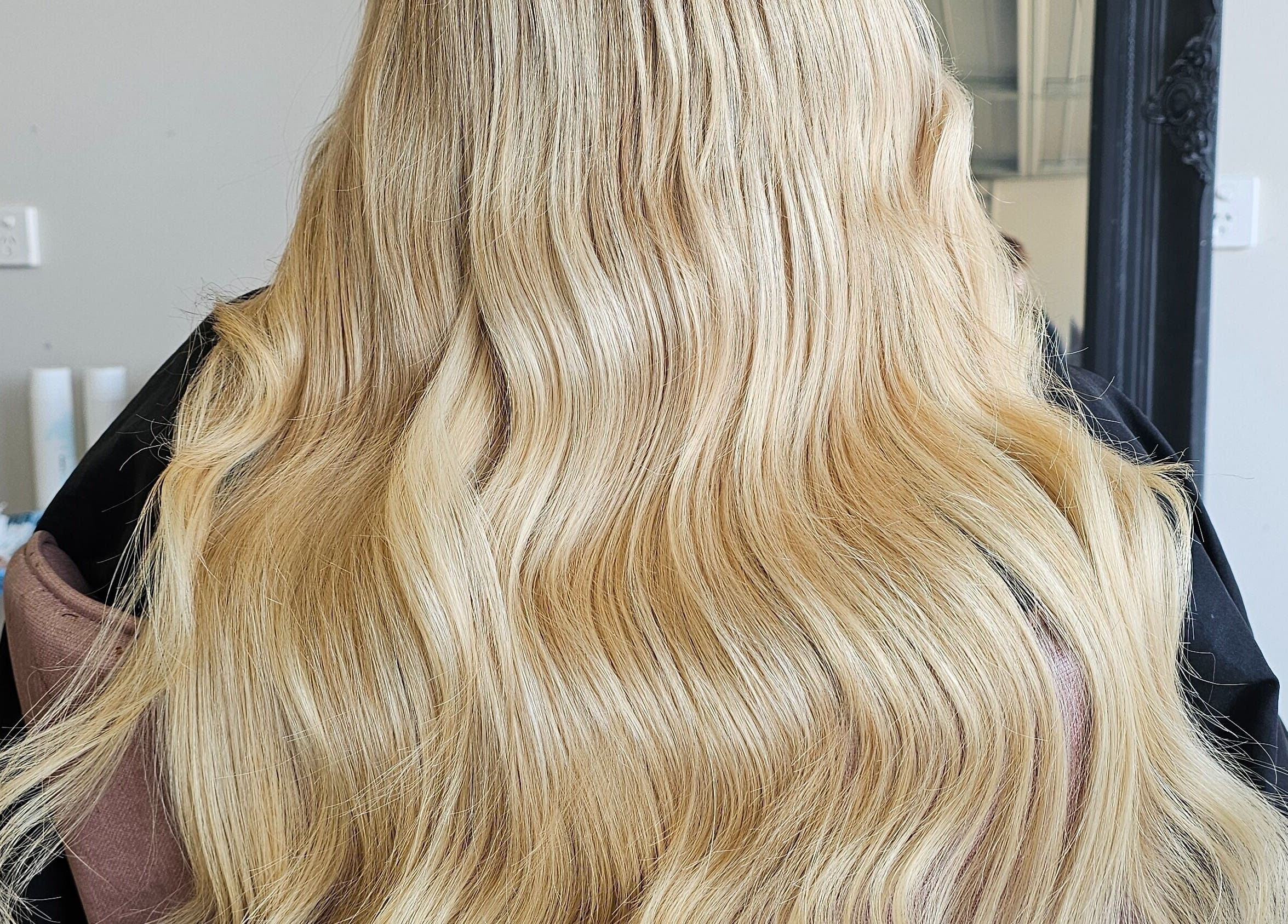Long, wavy blonde hair styled at Tease by Jess in Mildura, Victoria, AU.