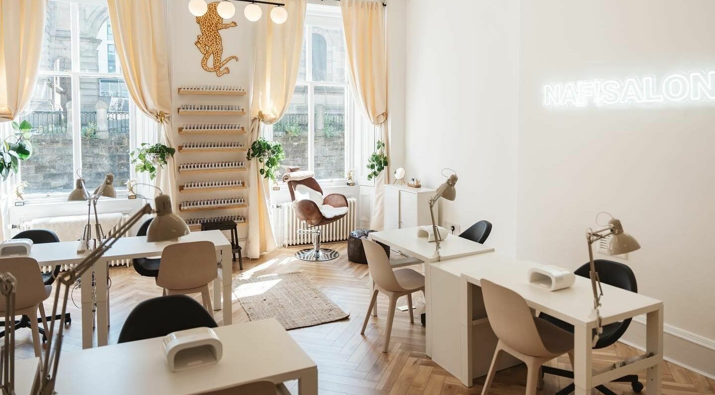 NAF Salon's elegant interior in Glasgow, Scotland, GB, featuring modern nail stations and cozy seating.