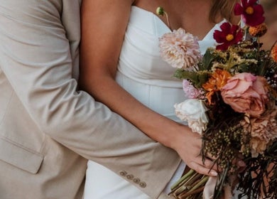Couple embracing with a bouquet at Meg You Glow, Heber City, Utah, US.