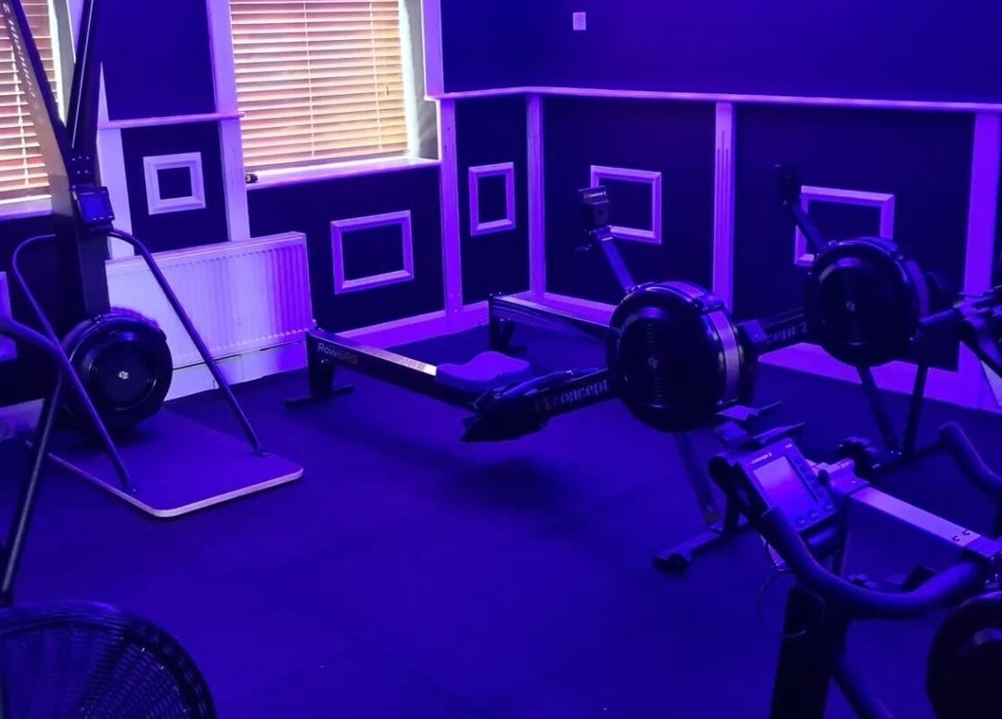 Modern fitness equipment at Elevate Gym + Athlete Recovery, Clogher, Northern Ireland, GB under neon lights.