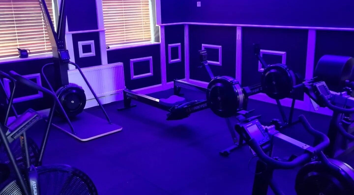 Modern fitness equipment at Elevate Gym + Athlete Recovery, Clogher, Northern Ireland, GB under neon lights.