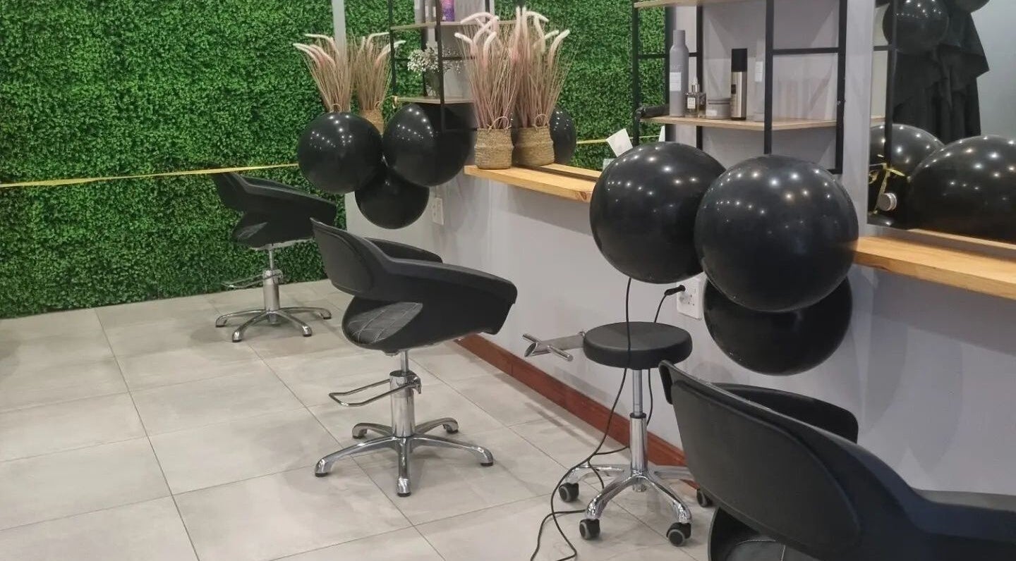 Modern salon interior at Hair Aroma, Pretoria, Gauteng, ZA, features stylish chairs and greenery accents.